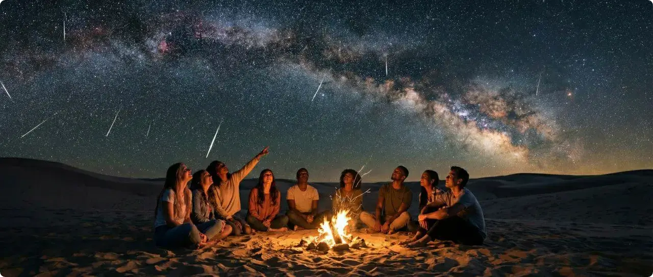 گروهی از جوانان در حال تماشای بارش شهابی و آسمان پرستاره در کویر